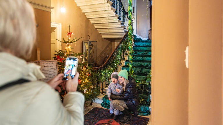 Mother and young child exploring the Christmas decorations at Llanerchaeron, Ceredigion